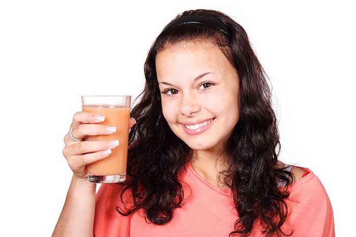 A girl holding glass of juice in her hand